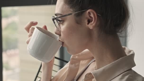 Jonge Mooie Geconcentreerde Vrouw Zitten Binnen Het Drinken Van Koffie — Stockvideo