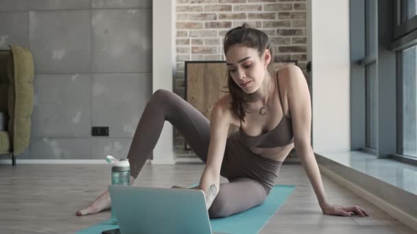 Jovem Mulher Fitness Bonita Concentrada Tapete Dentro Casa Usando Computador — Vídeo de Stock