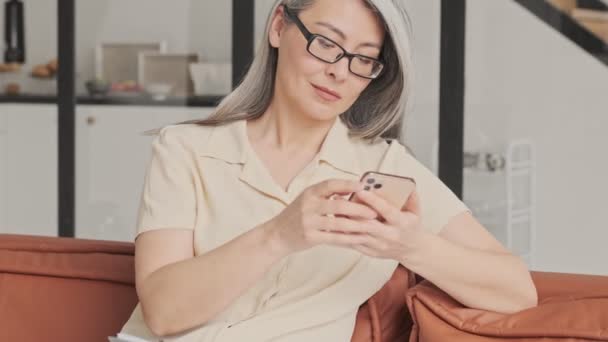 Miła Dojrzała Kobieta Okularach Długimi Siwymi Włosami Używa Smartfona Siedzącego — Wideo stockowe