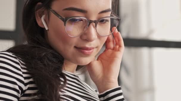 Cerca Vista Sonriente Bonita Mujer Asiática Gafas Auriculares Sentado Sofá — Vídeo de stock