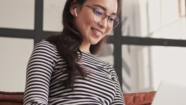 Feliz Mujer Asiática Bonita Gafas Auriculares Usando Computadora Portátil Mientras — Vídeos de Stock