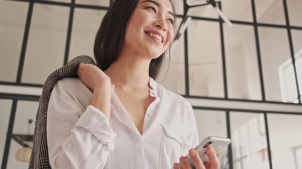 Θέα Από Κάτω Του Χαρούμενα Όμορφη Ασιατική Γυναίκα Χρησιμοποιώντας Smartphone — Αρχείο Βίντεο