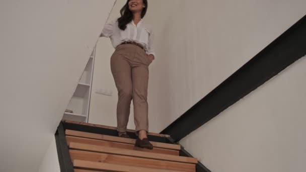 快乐优雅优雅的亚洲女人走在楼梯上 手插在口袋里在家里 — 图库视频影像