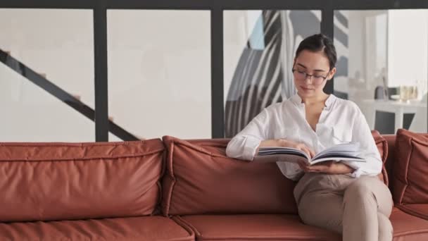 Calm Elegant Pretty Asian Woman Eyeglasses Reading Magazine While Sitting — Stock Video