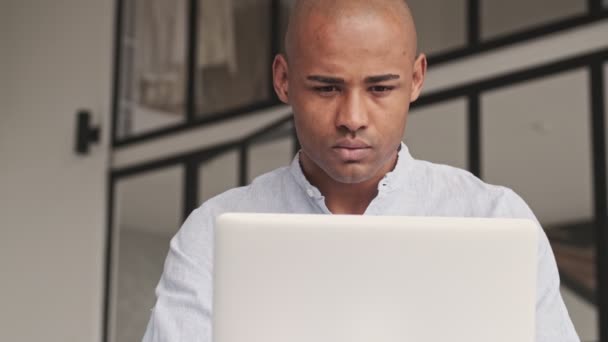 Сфокусований Афроамериканець Дивиться Свій Ноутбук Який Сидить Столом Вітальні Вдома — стокове відео