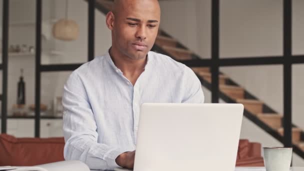 Een Knappe Afro Amerikaanse Man Gebruikt Zijn Laptop Terwijl Hij — Stockvideo