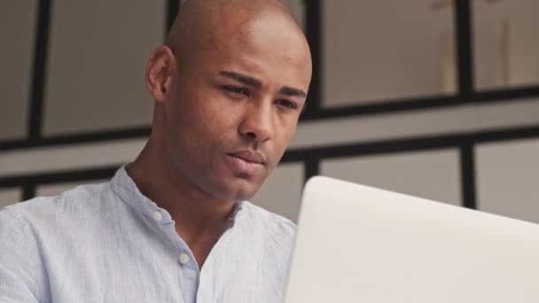 一位严肃的非洲裔美国人的近照是 他正坐在家中的笔记本电脑旁 — 图库视频影像