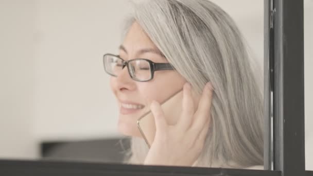 Šťastná Zralá Žena Brýlemi Mluví Svém Smartphonu Stojící Obývacím Pokoji — Stock video