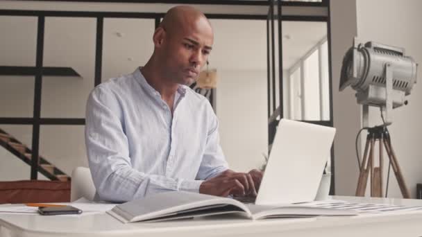 Odaklanmış Afrikalı Amerikalı Bir Adam Dizüstü Bilgisayarında Evde Oturuyor — Stok video