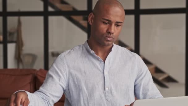 Улыбающийся Африканский Американец Смотрит Своем Ноутбуке Гостиной Дома — стоковое видео