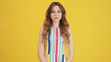 Mutlu bir kadın evet diye bağırıyor ve seviniyor. Sarı bir arka planda tek başına duruyor.