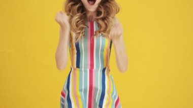 Ciddi bir kadın ellerini çaprazlarken hayır diyor. Sarı bir arka planda izole edilmiş.