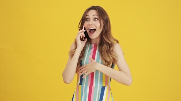 Emotional Surprised Excited Woman Talking Her Smartphone Standing Isolated Yellow — Stock Video