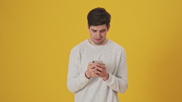 Δυστυχισμένος Άρρωστος Άνθρωπος Γράφει Μήνυμα Στο Smartphone Πάνω Από Κίτρινο — Αρχείο Βίντεο