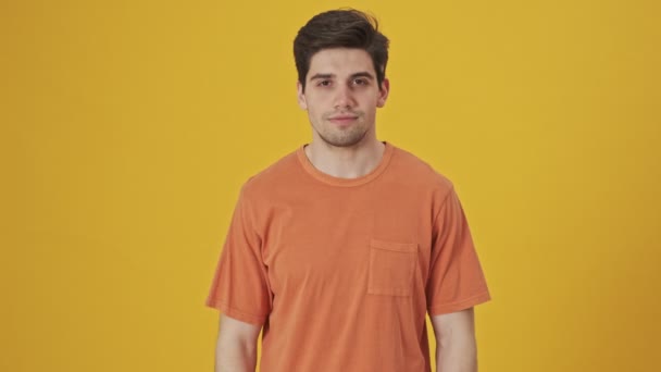 Šťastný Pohledný Muž Tričku Mává Dlaní Kameru Přes Žluté Pozadí — Stock video