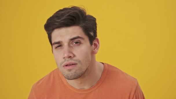 Tişört Giymiş Gülümseyen Yakışıklı Adamın Sarı Arka Plandaki Aynaya Bakarken — Stok video