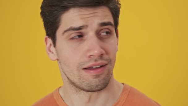 Tişörtlü Sakin Yakışıklı Bir Adamın Etrafa Bakınışının Sarı Arka Planda — Stok video