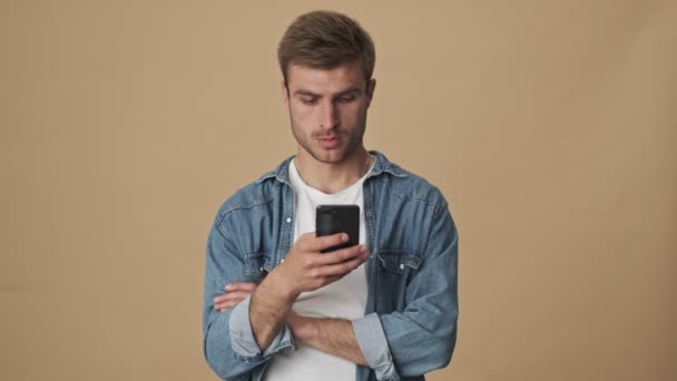 Joven Sorprendido Está Viendo Algo Teléfono Inteligente Pie Sobre Pared — Vídeo de stock