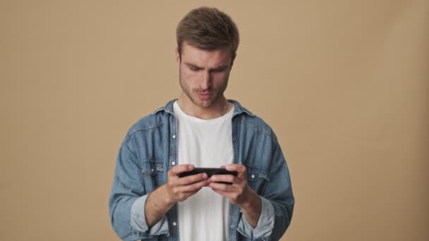 Een Serieuze Geconcentreerde Jongeman Speelt Een Spel Zijn Smartphone Houdt — Stockvideo