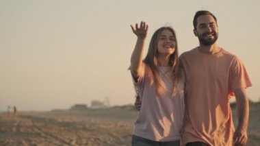 Genç bir çiftle kadın sahilde çıkıyorlar.