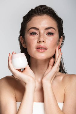 Gri arka planda ıslak, uzun saçlı, çekici ve şehvetli bir kadının güzel portresi.