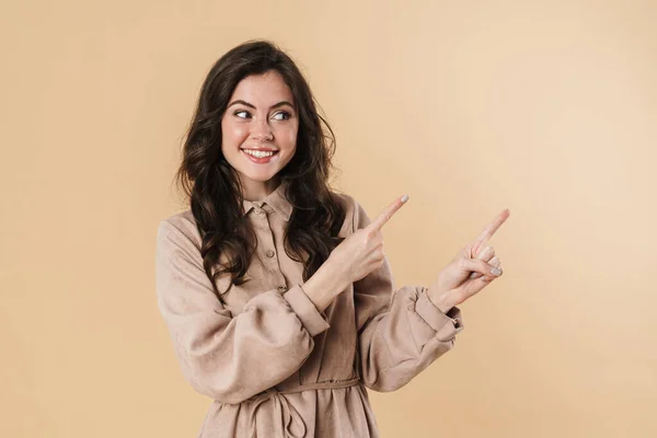 Image Cheerful Attractive Woman Smiling Pointing Fingers Aside Isolated Beige — Stock Photo, Image