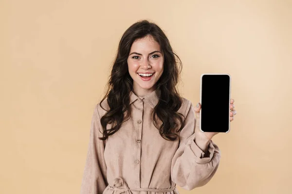 照片上快乐迷人的女人笑着 手机在米色背景下被隔离 — 图库照片