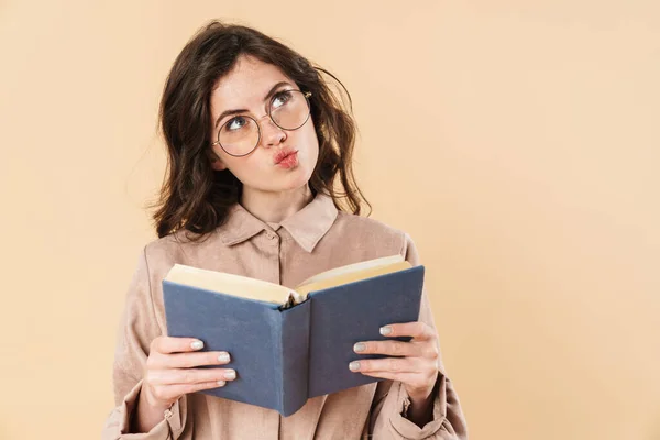 Image Thinking Caucasian Woman Eyeglasses Reading Book Isolated Beige Background — Stock Photo, Image
