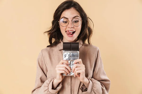 Gözlüklü Heyecanlı Beyaz Kadın Bej Arka Planda Izole Edilmiş Çikolatayla — Stok fotoğraf