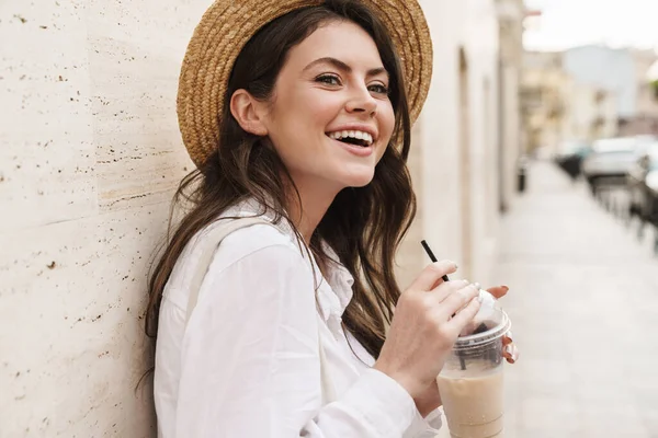 在城市街道上散步时 美丽快乐的女人笑着喝着奶昔的画像 — 图库照片