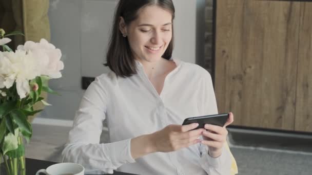 若いです素晴らしい正のチーズビジネス女性屋内でホーム使用して携帯電話 — ストック動画