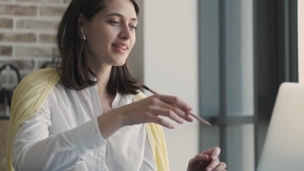 Genç Iyimser Neşeli Kadını Evde Bilgisayarın Kablosuz Kulaklıkla Yaptığı Video — Stok video