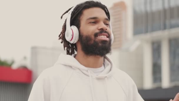 아프리카 남자가 헤드폰으로 음악을 밖에서 나오는 기뻐하다 — 비디오