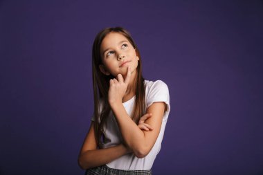 Güzel bir kızın poz verip yukarı baktığının fotoğrafı mor arka planda izole edilmiş.