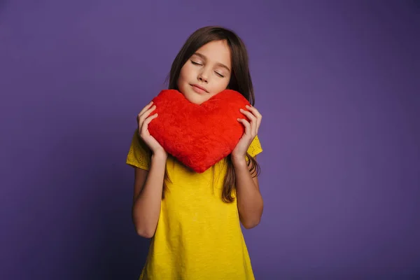 Foto Hermosa Niña Complacida Sosteniendo Corazón Del Juguete Suave Con —  Fotos de Stock