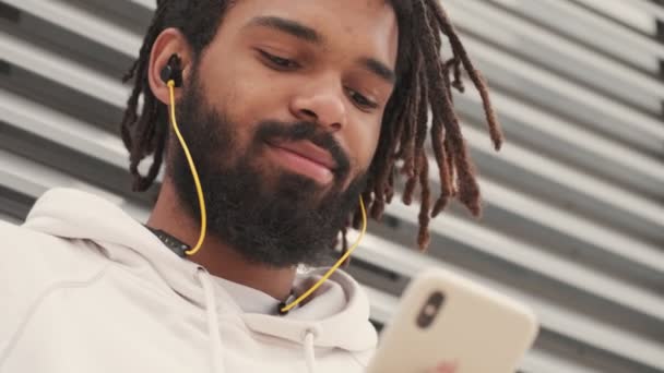 Beau Homme Africain Positif Extérieur Écoutant Musique Par Des Écouteurs — Video