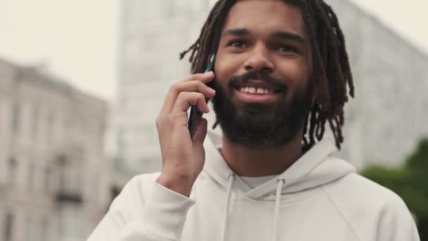 Guapo Joven Africano Positivo Caminando Por Calle Aire Libre Hablando — Vídeos de Stock