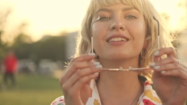 Een Mooie Jonge Blonde Vrouw Zet Een Zonnebril Poseert Voor — Stockvideo