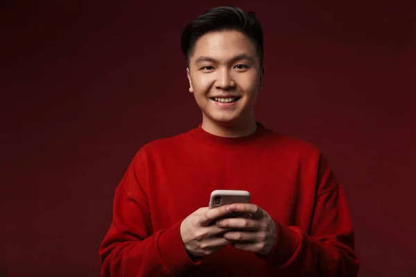 Bild Von Fröhlichen Jungen Asiatischen Mann Lächelnd Und Mit Handy — Stockfoto