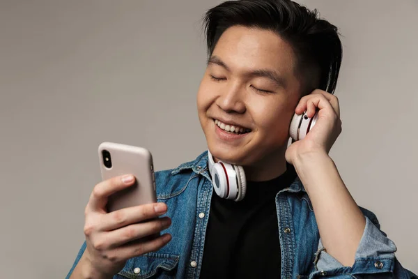 Image Smiling Young Asian Man Using Smartphone Wireless Headphones Isolated — Stock Photo, Image