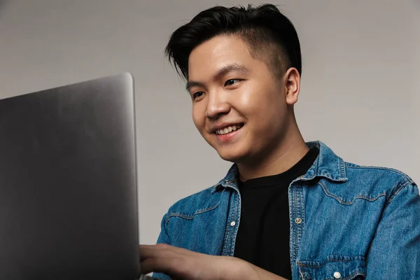 Image Cheerful Handsome Asian Man Smiling Using Laptop Isolated Gray — Stock Photo, Image