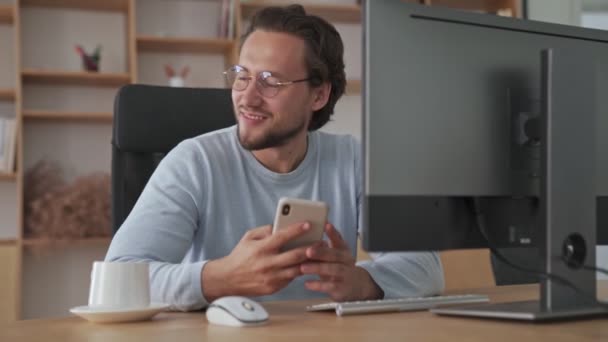 Joven Hombre Negocios Guapo Está Usando Teléfono Inteligente Sentado Oficina — Vídeo de stock