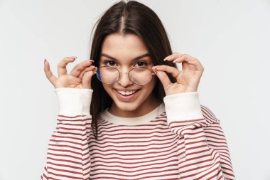 Gözlüklü, mutlu, esmer bir kadının fotoğrafı beyaz arka planda izole bir şekilde gülümsüyor.