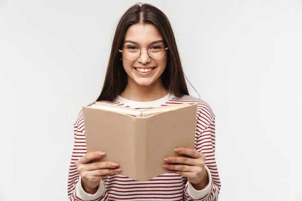 Zdjęcie Szczęśliwej Brunetki Młodej Kobiety Okularach Uśmiechającej Się Czytającej Książkę — Zdjęcie stockowe