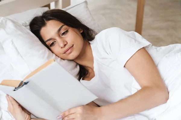 Uykudan Sonra Yatakta Uzanan Kestirirken Kitap Okuyan Mutlu Bir Kadının — Stok fotoğraf