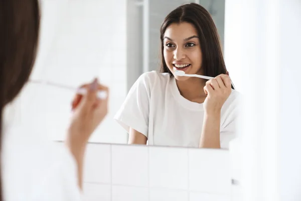 Foto Mulher Agradável Alegre Sorrindo Limpando Dentes Enquanto Olha Para — Fotografia de Stock