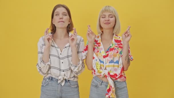 Dvě Usmívající Krásné Ženy Přání Zkříženými Prsty Gesta Přes Žluté — Stock video