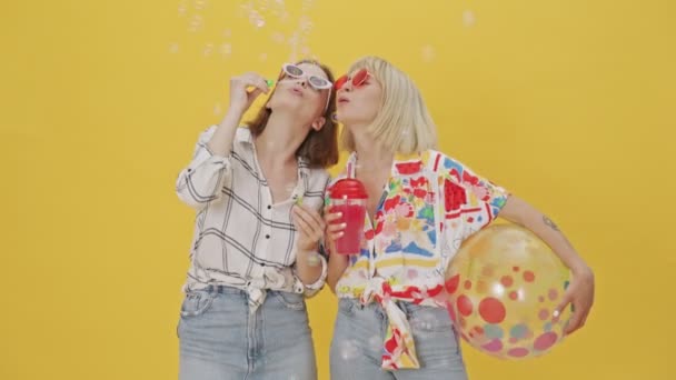 Zwei Fröhliche Hübsche Frauen Mit Sonnenbrille Amüsieren Sich Mit Seifenblasen — Stockvideo