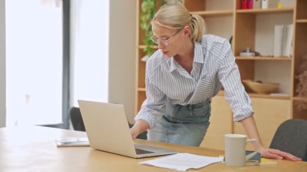 美しいですブロンドのビジネスマンはオフィスで彼女のラップトップコンピュータを使用しています — ストック動画