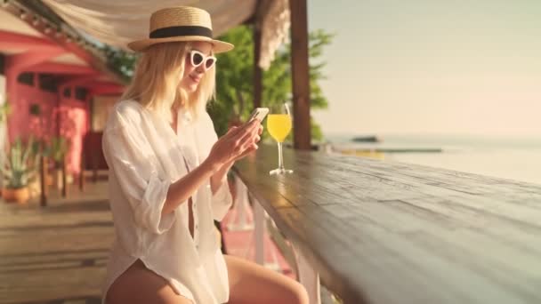 Eine Lächelnde Junge Blonde Frau Mit Sonnenbrille Und Hut Benutzt — Stockvideo
